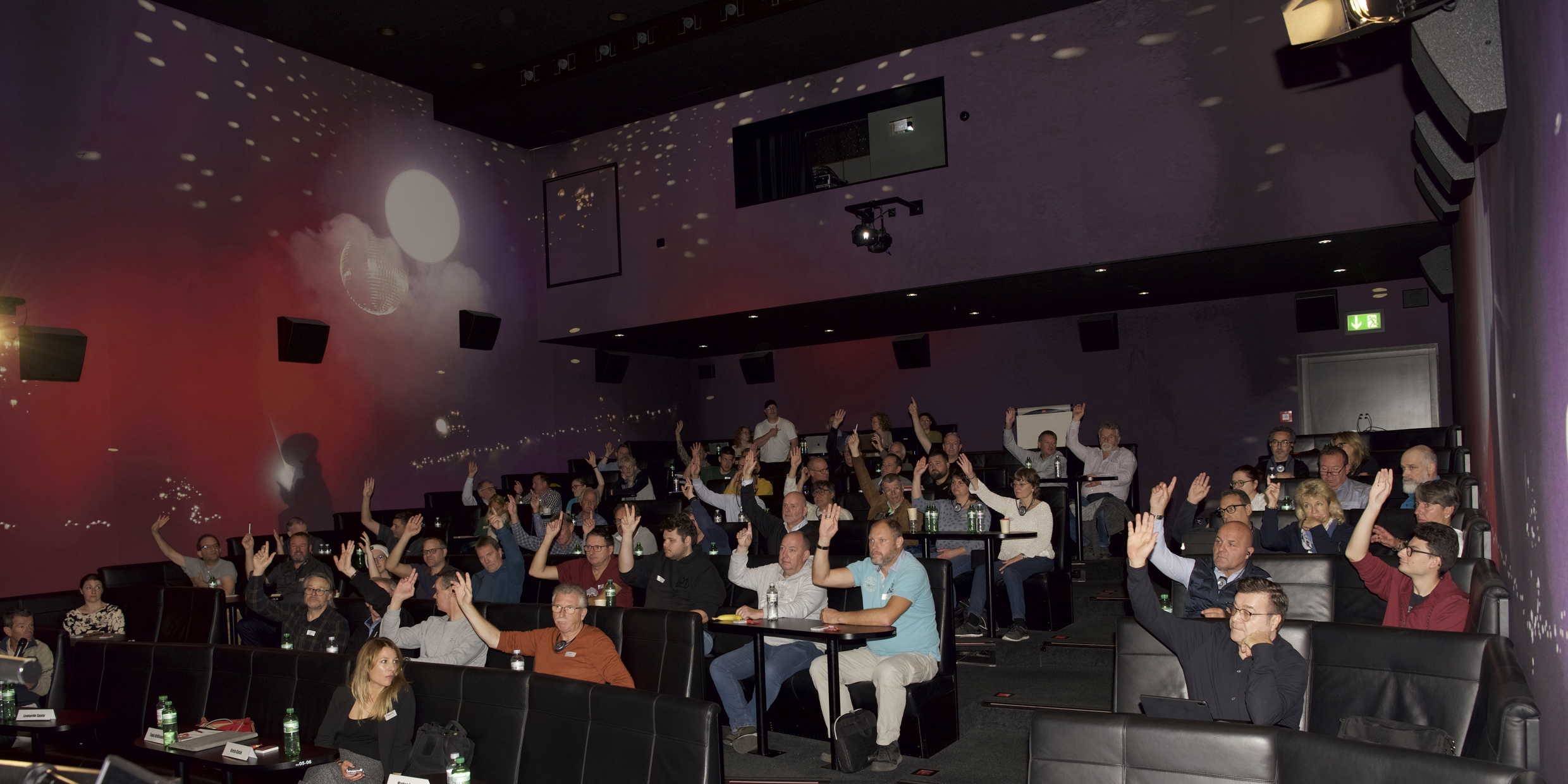 I partecipanti al cinema votano su varie questioni; la maggior parte di loro ha alzato la mano